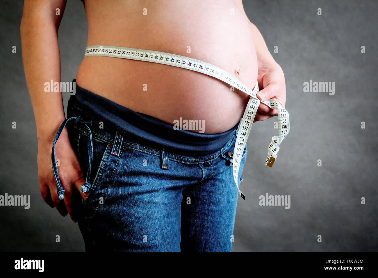 Schöne schwangere Frau zärtlich ihren Bauch messen Stockfoto