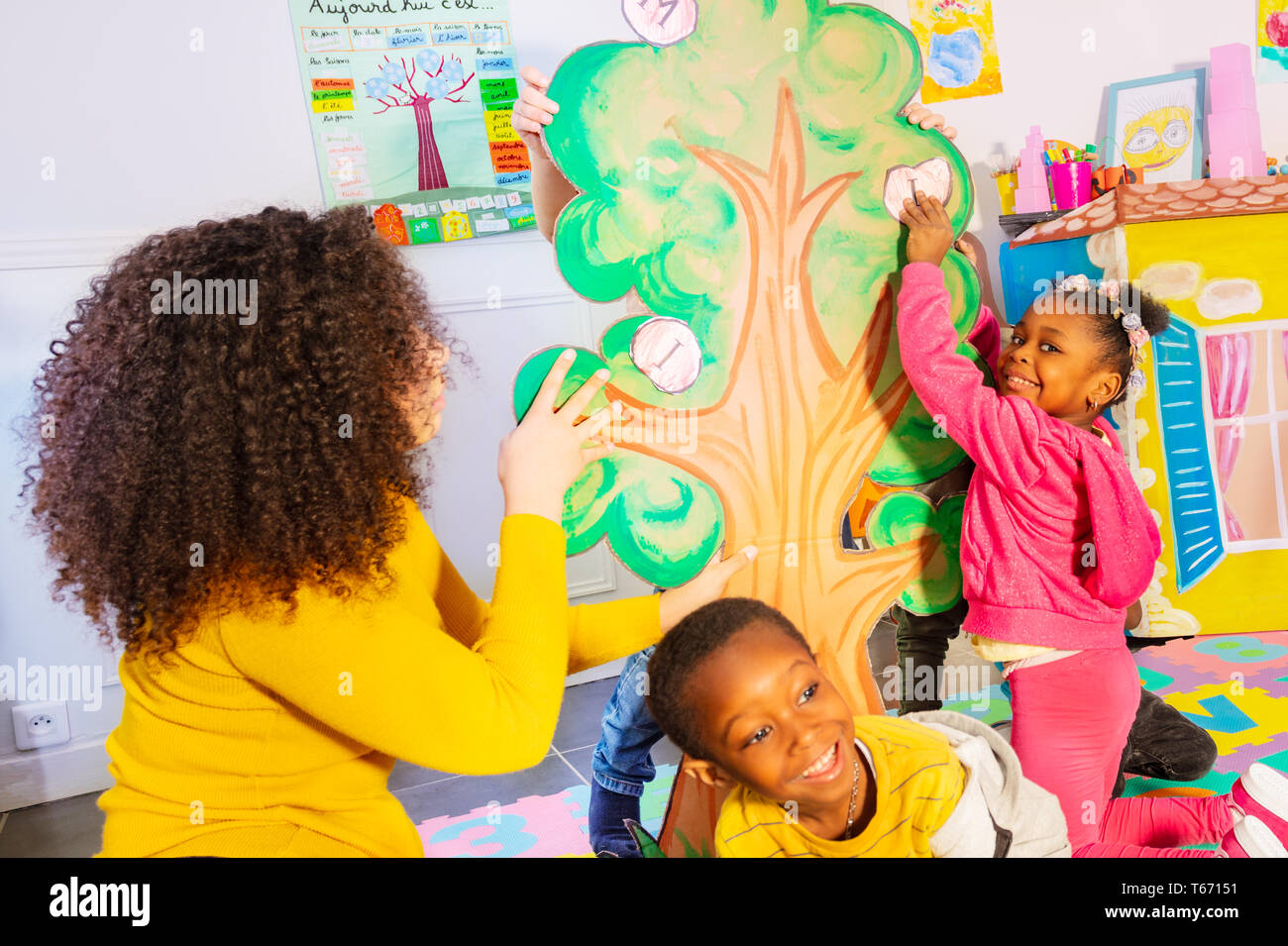 Lehrer mit Kindern Buchstaben auf dem Baum im Alphabet Spiel im Kindergarten Stockfoto