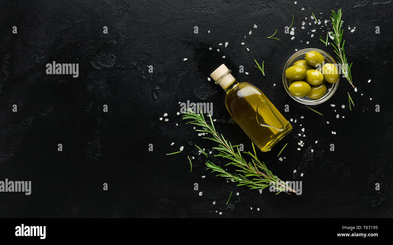 Olivenöl, frischen Oliven- und Rosmarinzweige auf schwarzem Hintergrund, Ansicht von oben, kopieren. Organic Olive Oil"-Konzept Stockfoto