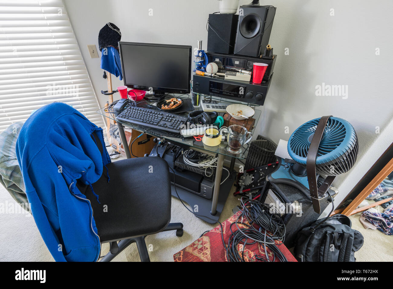 Sehr chaotisch, überladen Schreibtisch in Jungen im Teenageralter Schlafzimmer mit Musik-, Elektronik- und Sportgeräte. Stockfoto