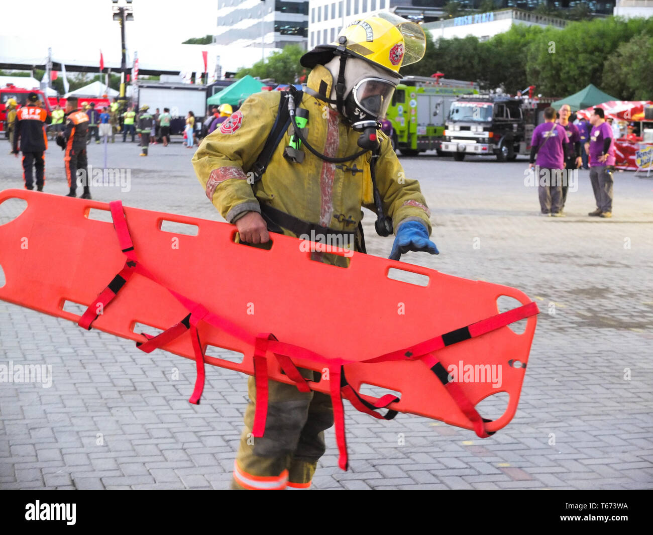 Ein Feuerwehrmann mit einer Sauerstoffmaske gesehen eine spine Board während des Wettbewerbs. Es ist ein jährlicher Wettbewerb der Feuerwehrleute ihre Brandbekämpfung Fähigkeit und ihre Kenntnisse in Rettung ein Brand Opfer durch die verschiedenen Situationen zu zeigen, von der Rettung zu kämpfen. Stockfoto