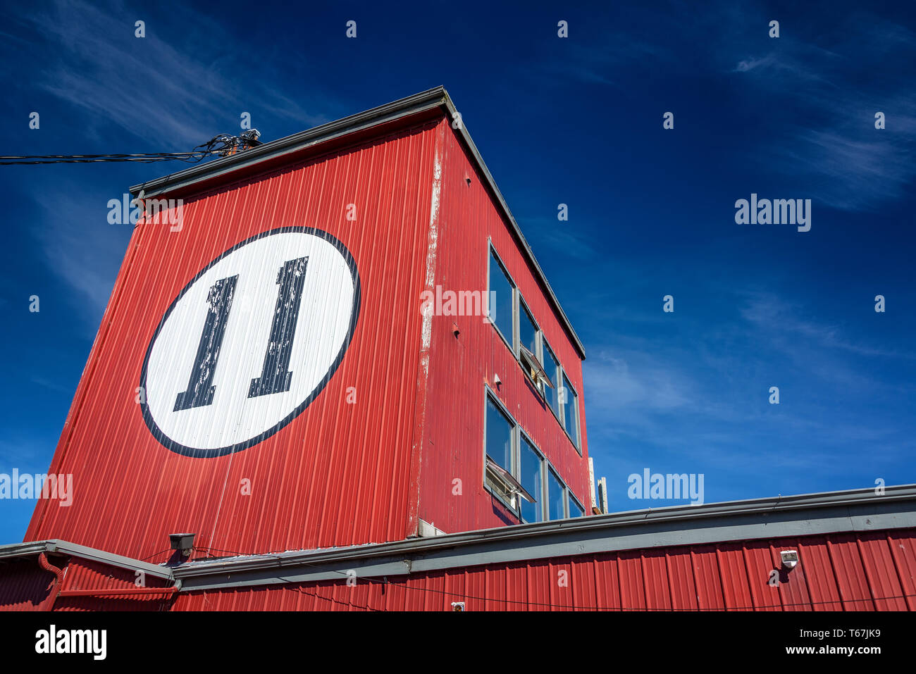 Rotes Gebäude mit der Nummer 11 an der Seite mit einem tiefblauen Himmel in Astoria, Oregon Stockfoto