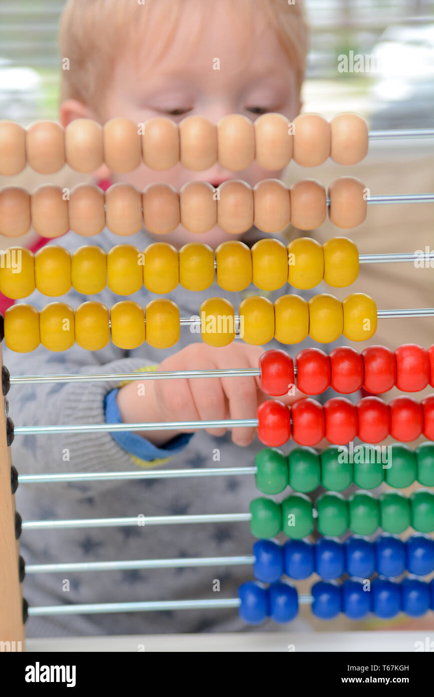 Kind lernen zu zählen. Junge mit einem abacus Mathe zu lernen Stockfoto