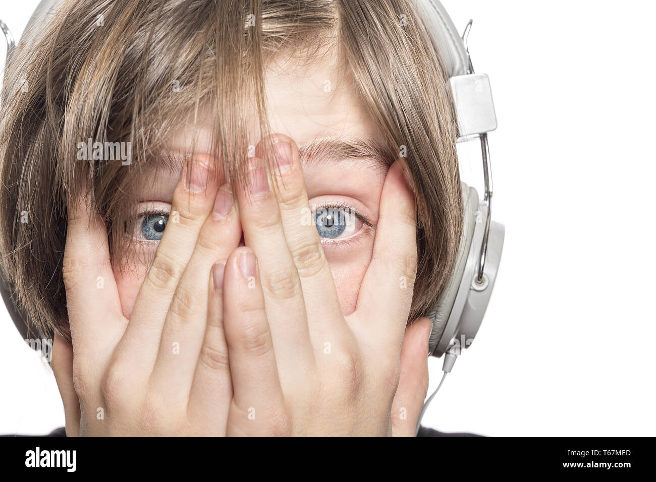 Verzweifelt männliche Teenager mit Kopfhörer bedeckte sein Gesicht mit den Händen Stockfoto