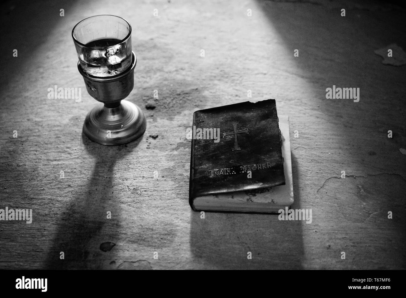 Heilige Bibel mit Rotwein in schwarz-weiß geschossen Stockfoto