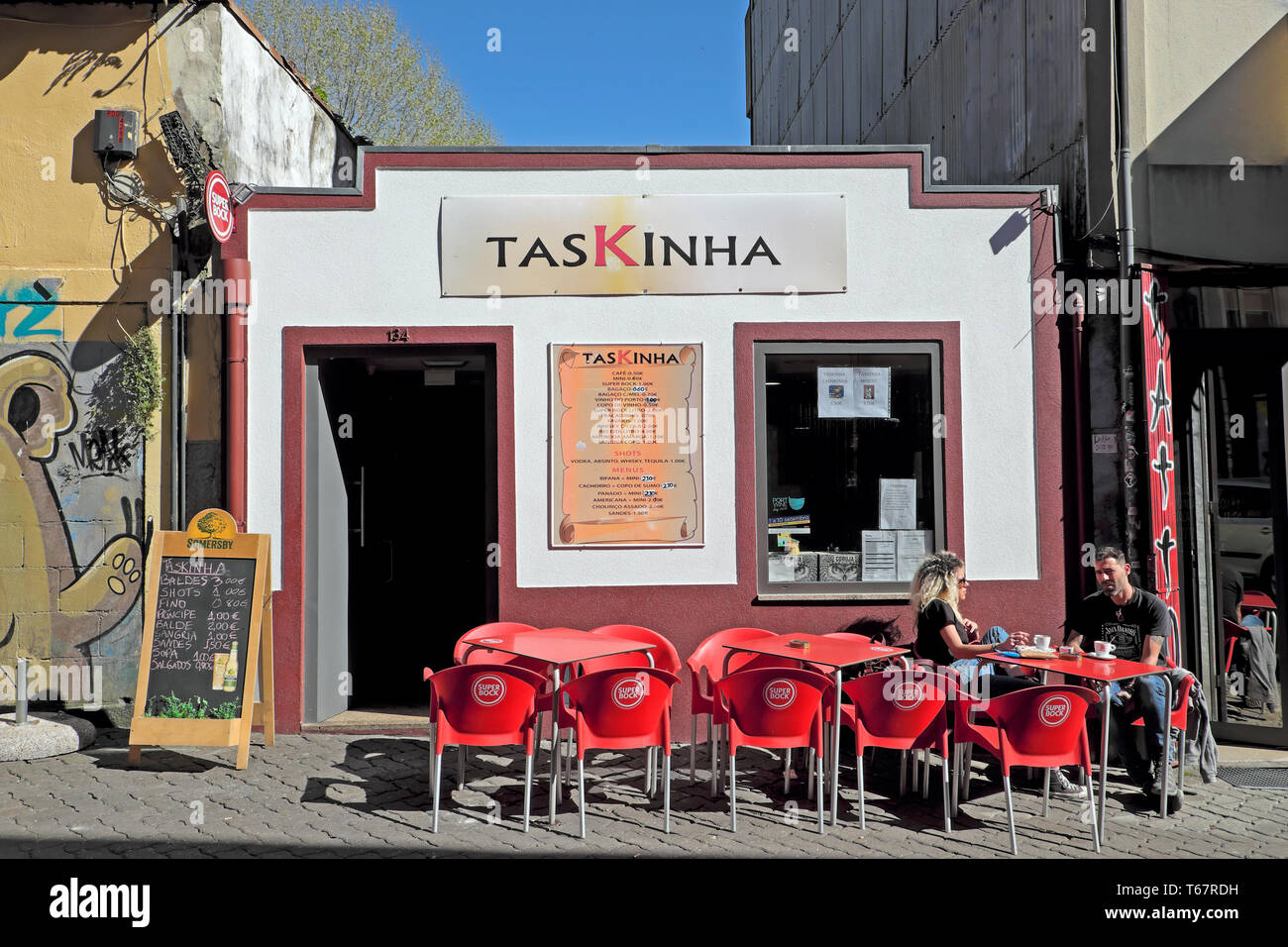 Außenansicht des TasKinha Bar und ein Paar draußen sitzen an Tischen trinken in Porto, Oporto, Portugal KATHY DEWITT Stockfoto