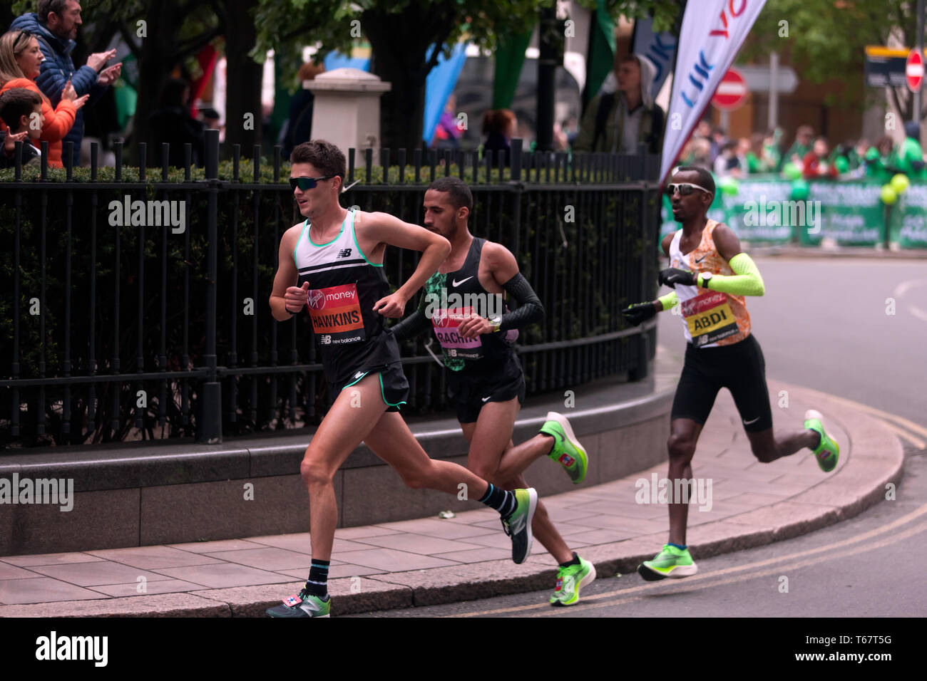 Callum Hawkins (GBR), Yassine Rachik (ITA) und Bashir Abdi (BEL), kämpft es sich um Canary Wharf, während der 2019 London Marathon. Sie fuhr fort, zu 10., 9. und 7. Jeweils im Elite Rennen der Männer beenden. Stockfoto