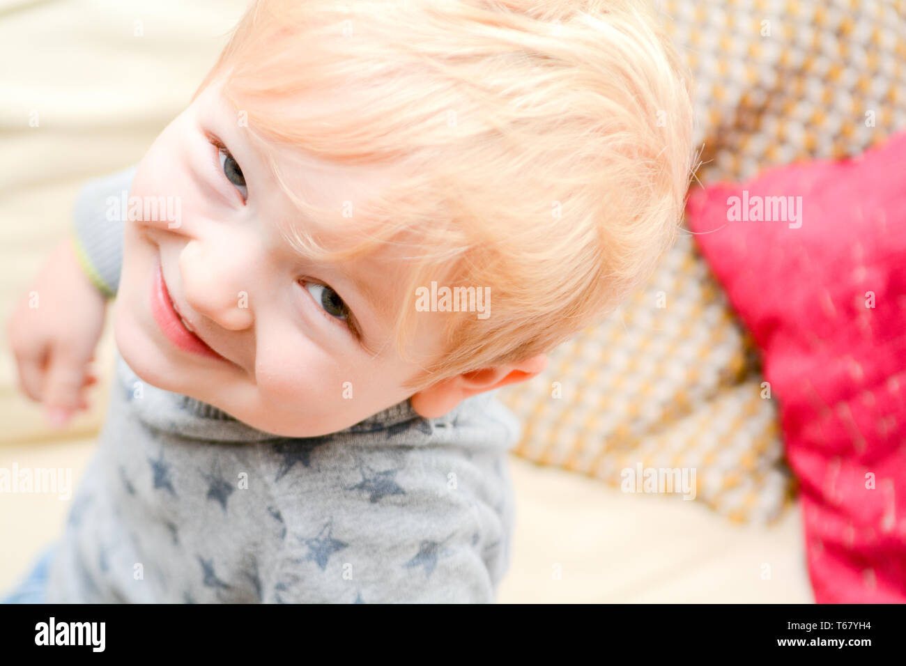 Glückliches Kind zu Hause direkt auf der Kamera. Süße blonde Junge lächelt Stockfoto