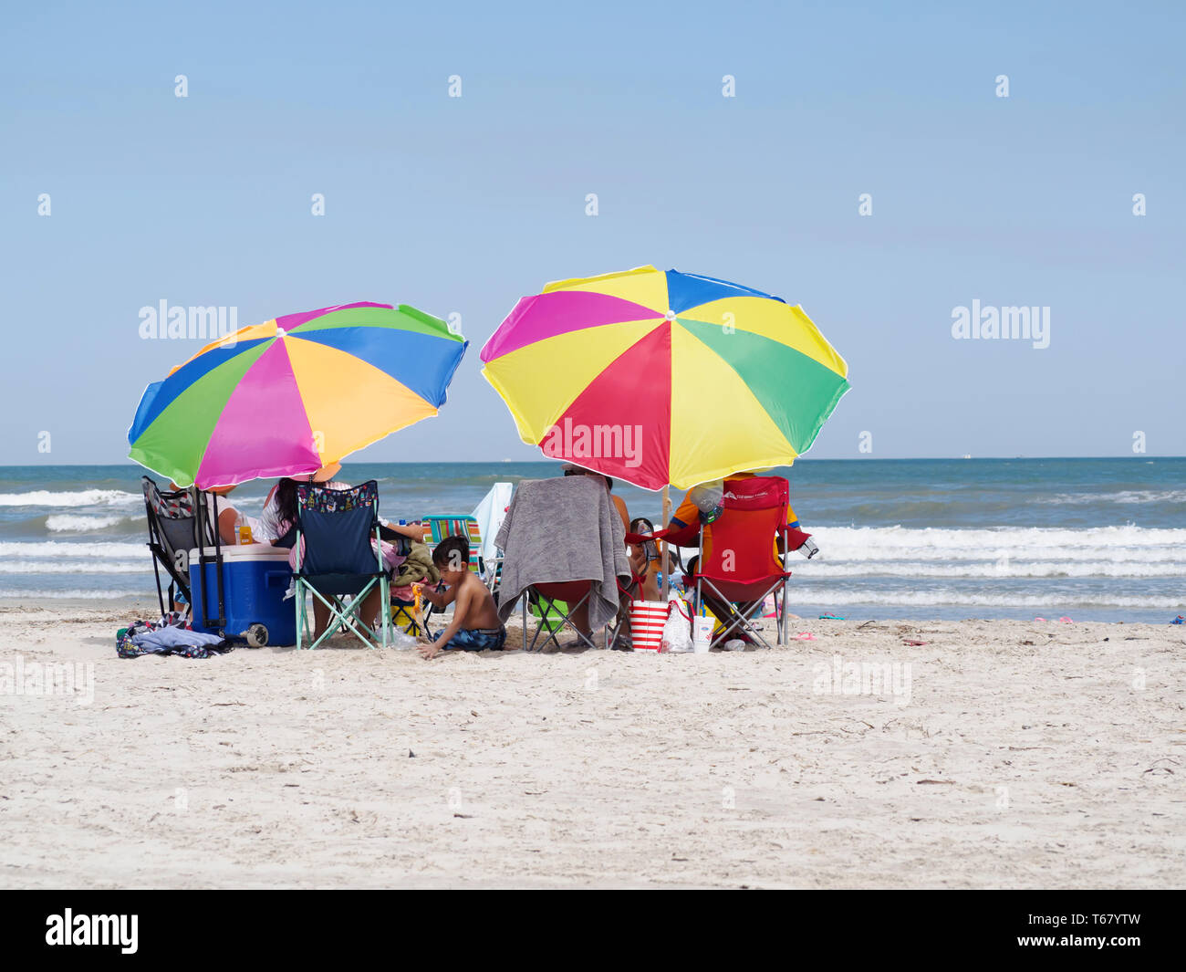 Bunte Sonnenschirme Schatten beachgoers auf einem Golf von Mexiko Strand während der 2019 Texas Sandfest in Port Aransas, Texas USA. Stockfoto