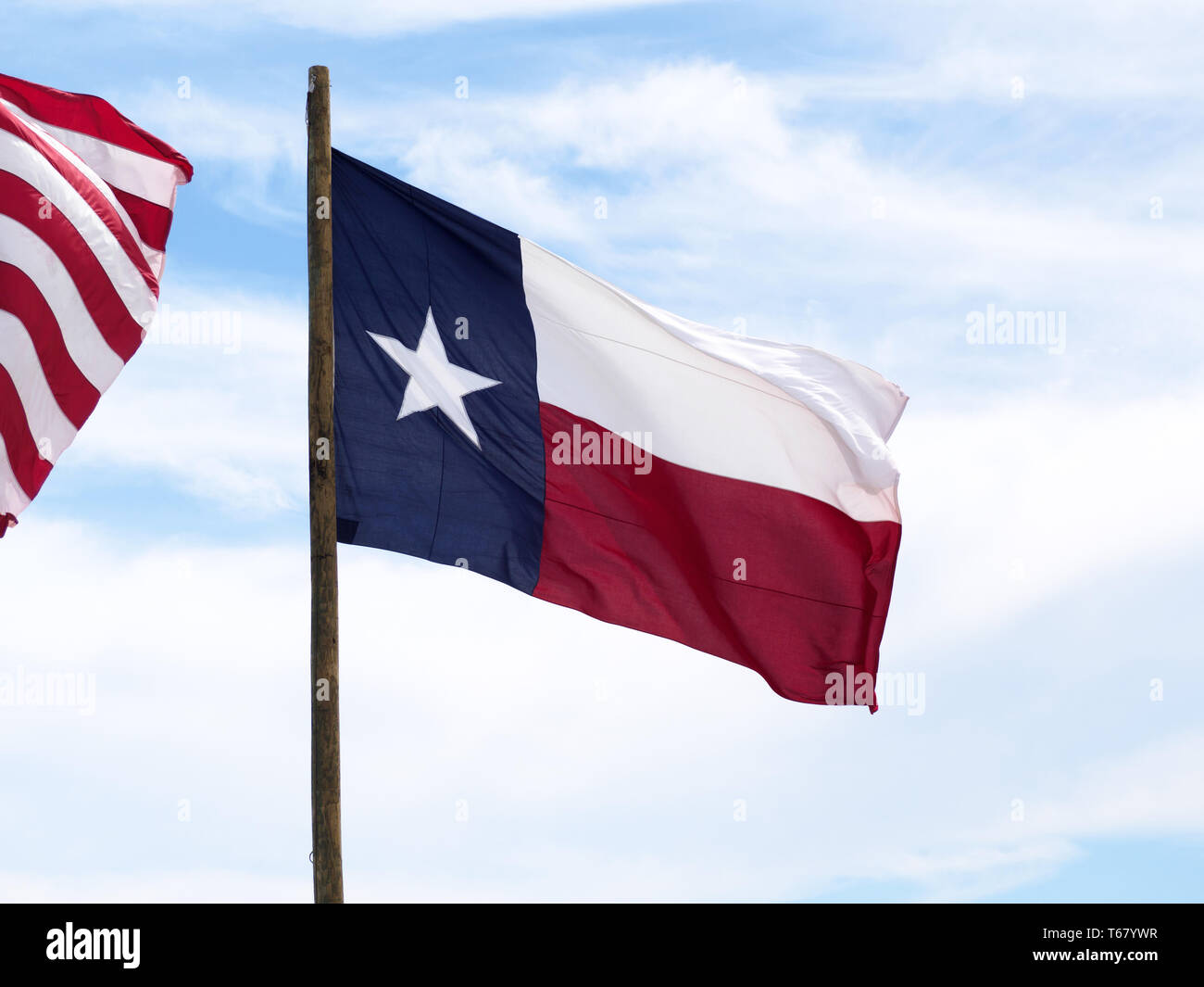 Das Texas State Flag oder 'Lone Star Flag", fliegt gegen den blauen Himmel mit weißen Wolken am2019 Texas Sandfest in Port Aransas, Texas USA. Stockfoto