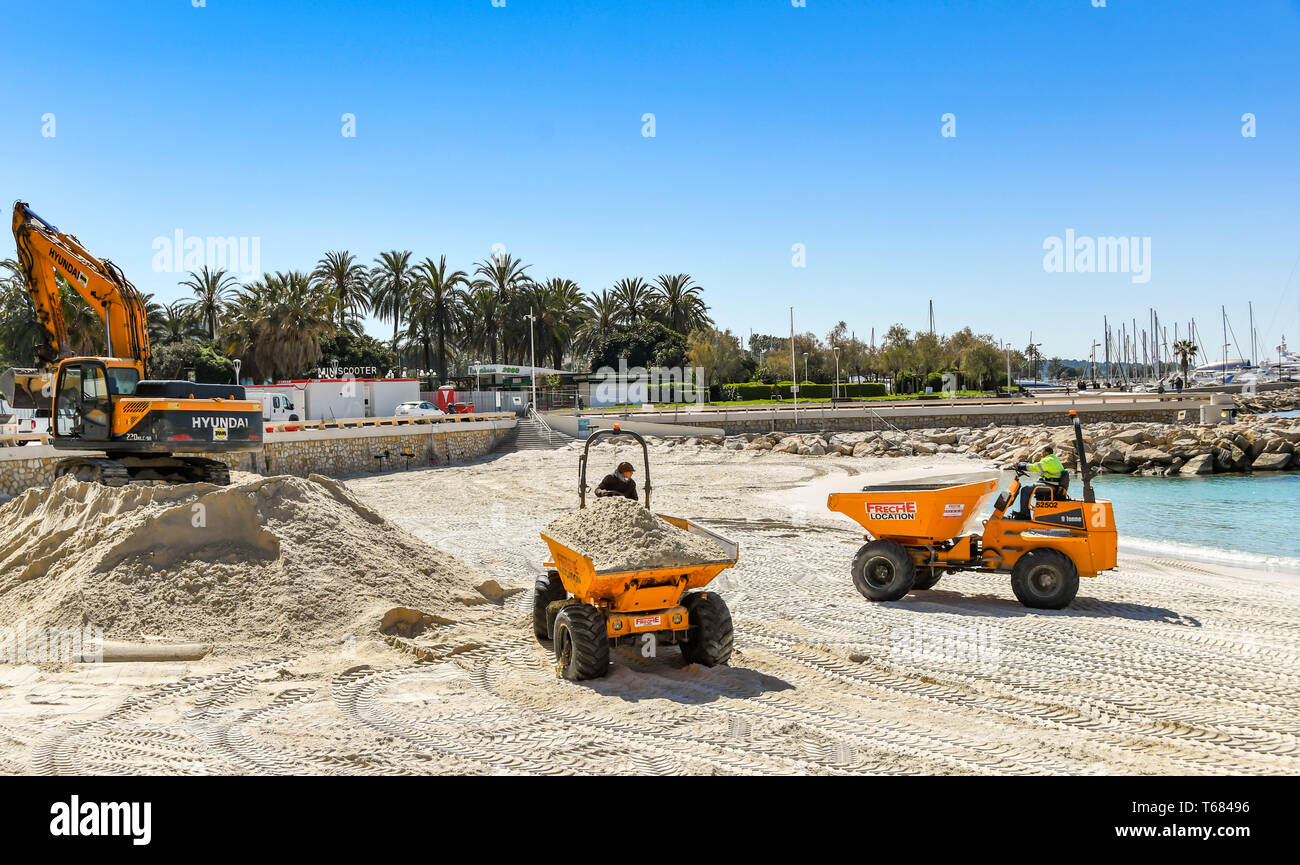 CANNES, Frankreich - April 2019: Muldenkipper transportieren Sand über den Strand in Cannes für den Frühling und Sommer Saison bereit, Stockfoto