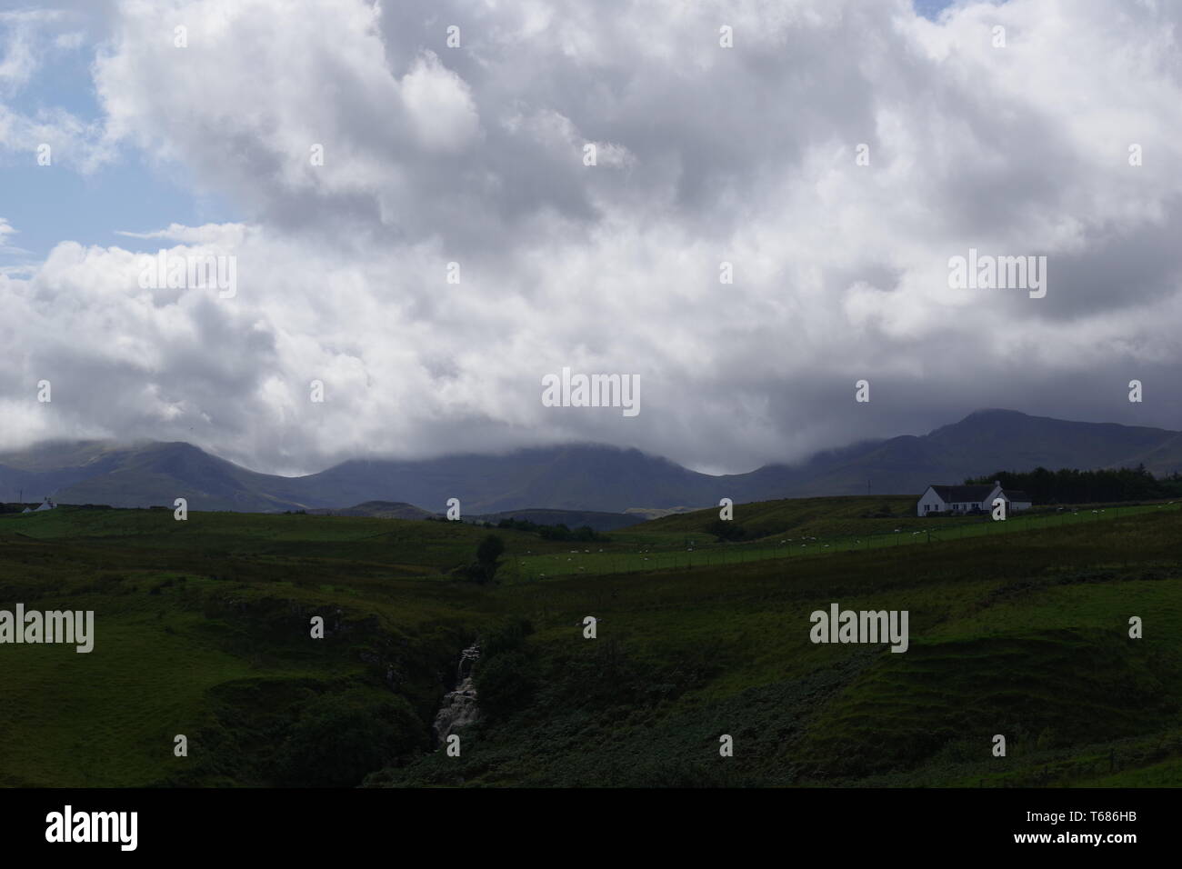 Lonfearn Brennen durch pulsierende grüne Landschaft unter niedrigen Cloud mit Berge bei Brüder Point (Rubha nam Brathairean) Isle of Skye, Schottland, Großbritannien. Stockfoto