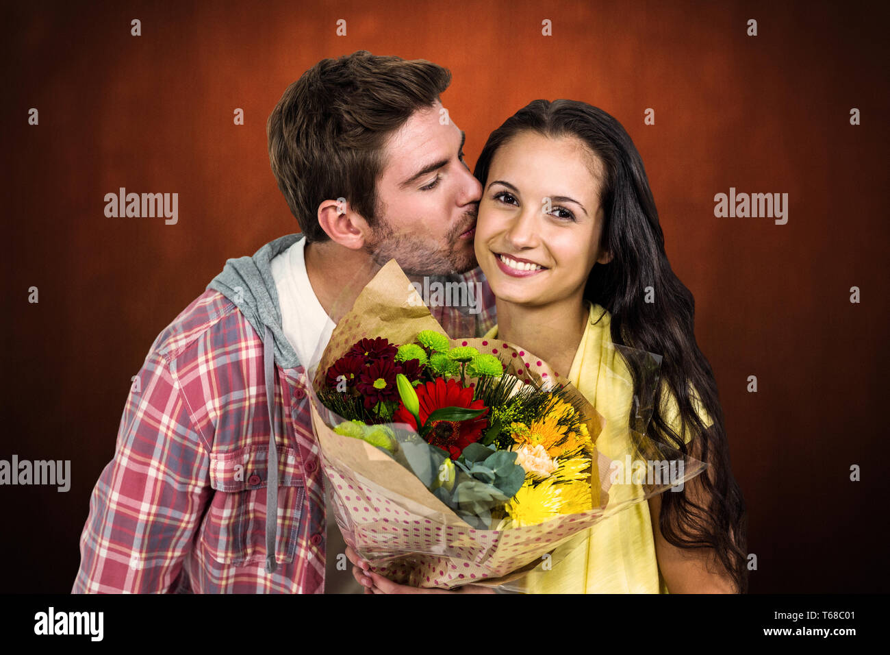 Zusammengesetztes Bild lächelnde Frau mit Blumenstrauß und wird von Freund geküsst Stockfoto