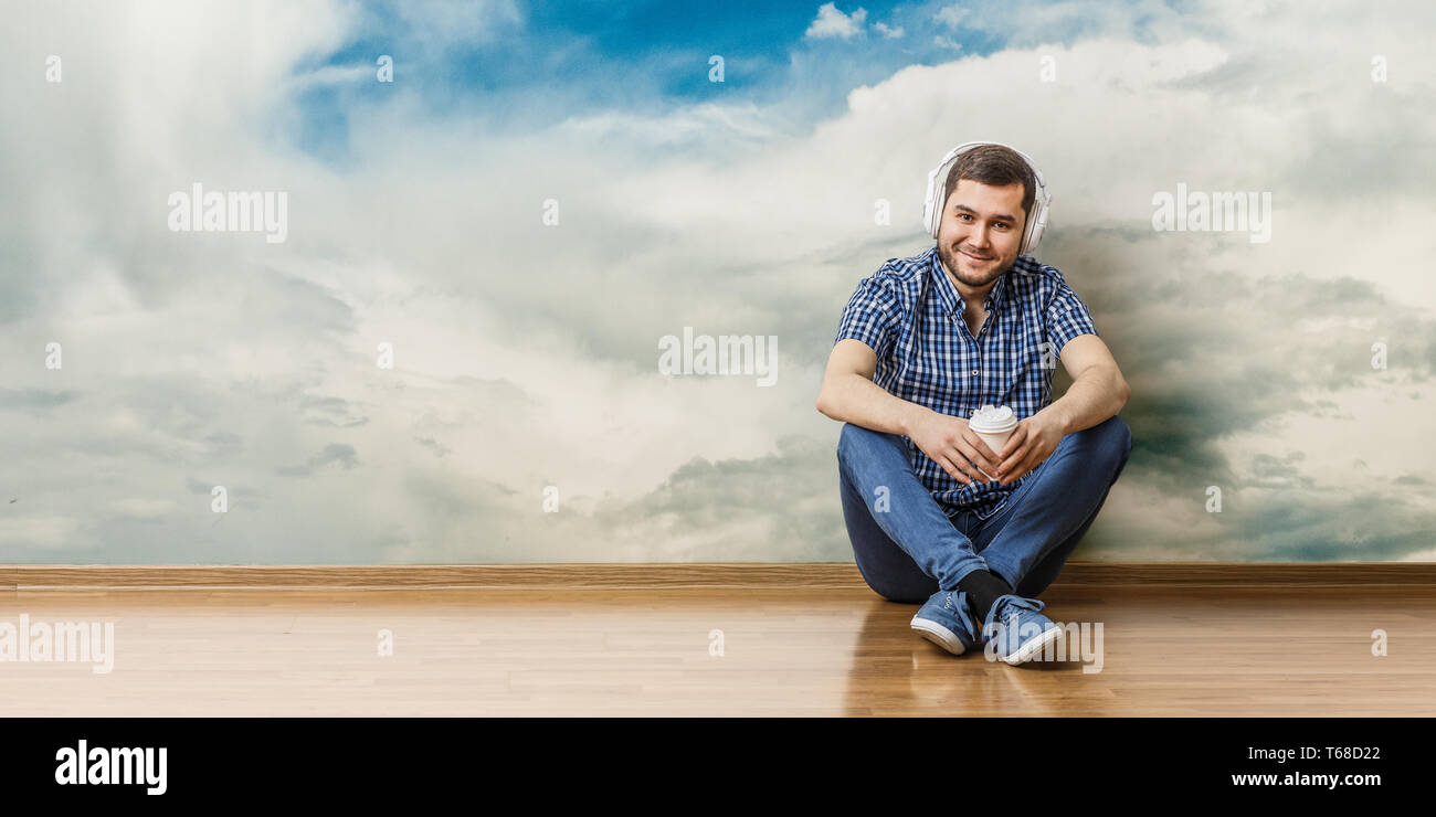 Junger Mann sitzen auf dem Boden, ein Moment für Konzept entspannen. Mixed Media Stockfoto