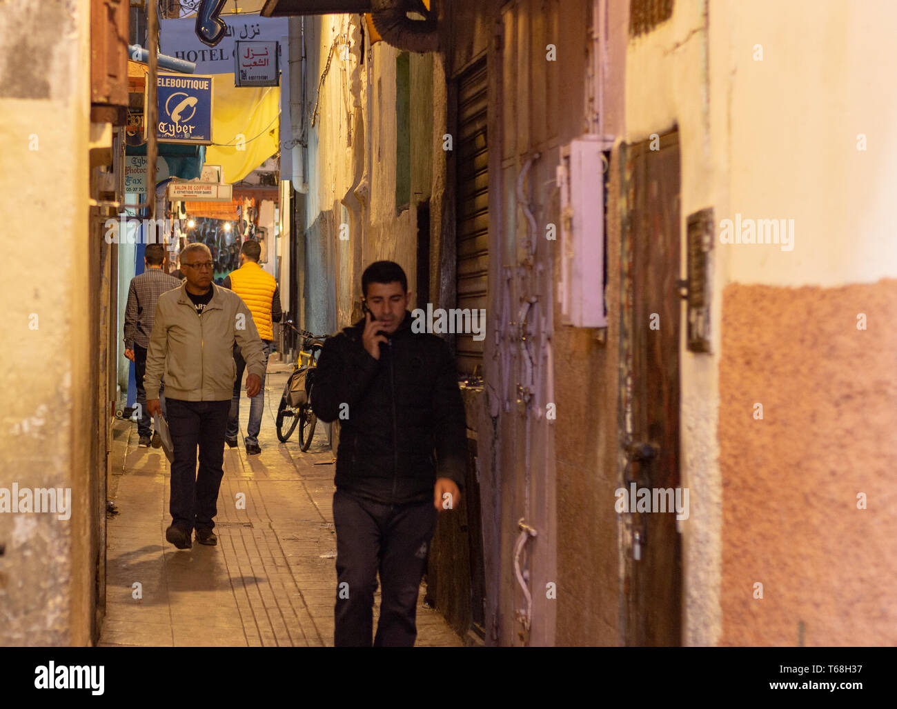 Medina von Rabat, Marokko, 27. April 2019. Zwei Männer zu Fuß auf einem der traditionellen, alten Straßen im Souk, wo viele Händler ihre Waren verkaufen. Stockfoto