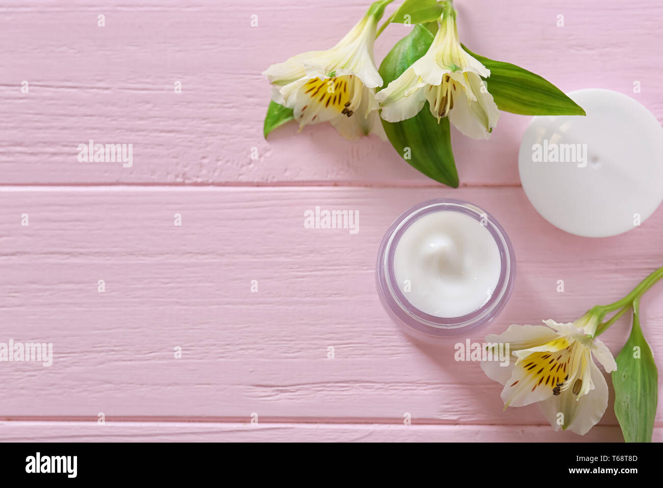Flach Komposition mit Hautpflege Kosmetik und Blumen auf Holz- Hintergrund Stockfoto