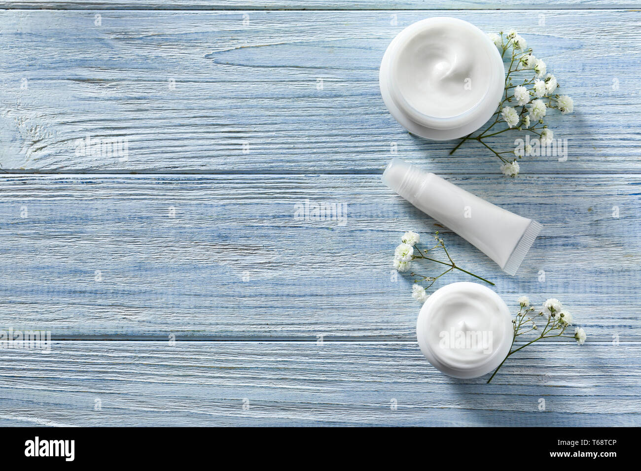 Flach Komposition mit Hautpflege Kosmetik und Blumen auf Holz- Hintergrund Stockfoto