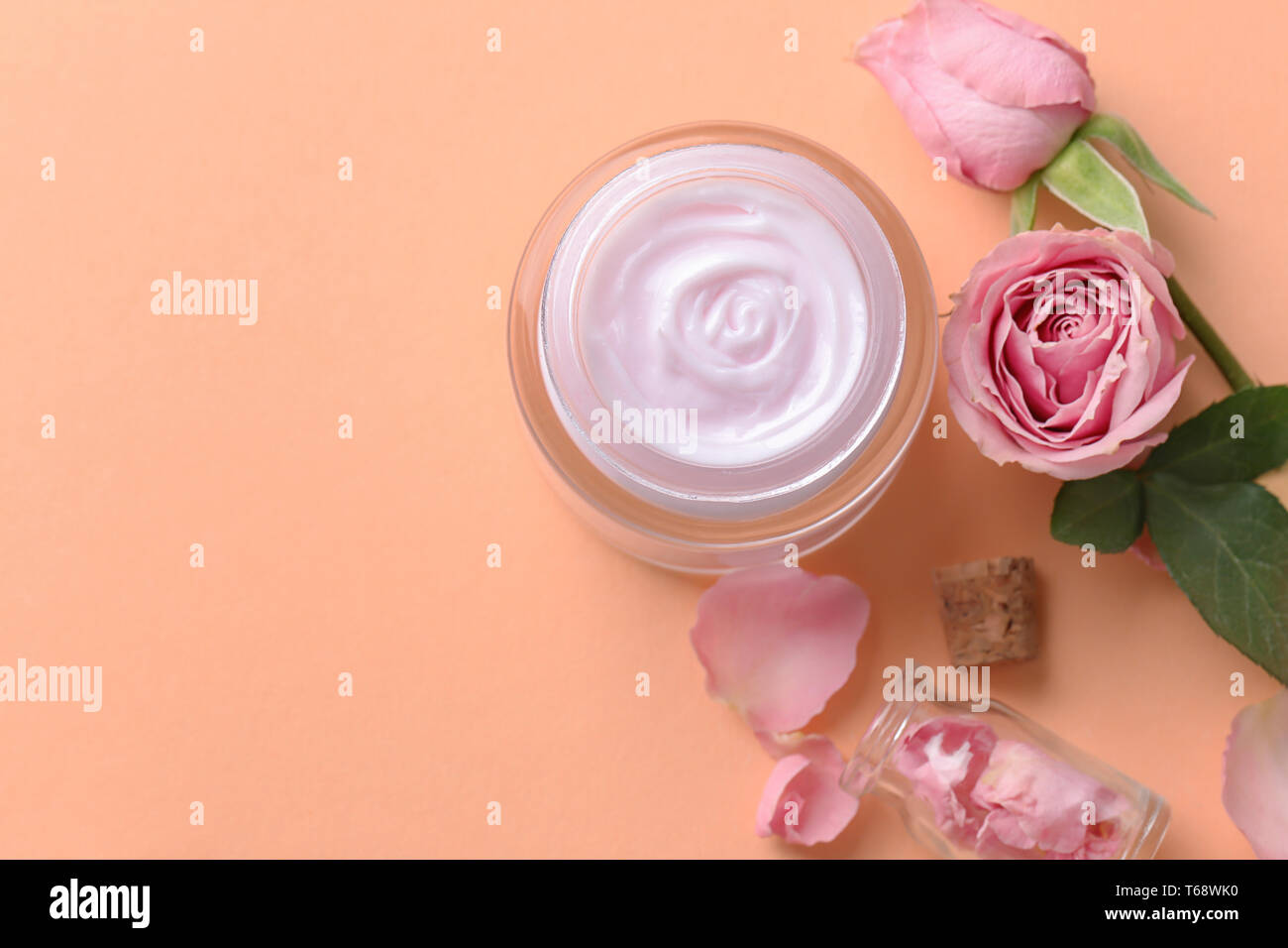Schöne Komposition mit Creme für den Körper und Blumen auf farbigen Hintergrund Stockfoto