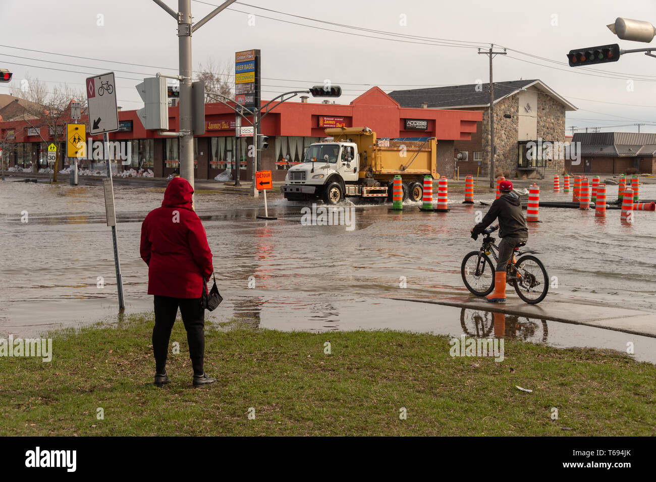 Pierrefonds-Roxboro, Quebec, Kanada - 29 April 2019: Menschen in einem versunkenen Straße im Frühjahr Hochwasser Stockfoto