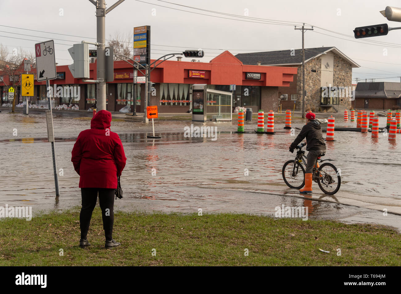 Pierrefonds-Roxboro, Quebec, Kanada - 29 April 2019: Menschen in einem versunkenen Straße im Frühjahr Hochwasser Stockfoto