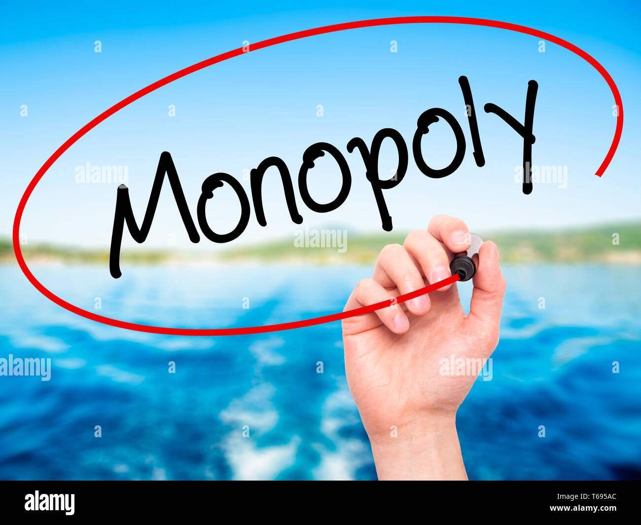 Mann Hand schreiben Monopol mit schwarzem Marker auf visuelle Bildschirm. Stockfoto