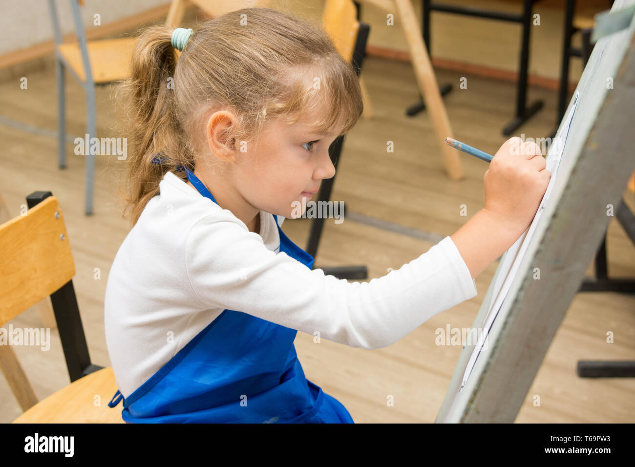 Fünfjähriges Mädchen Farben auf einer Staffelei in der Zeichnung Lektion Stockfoto