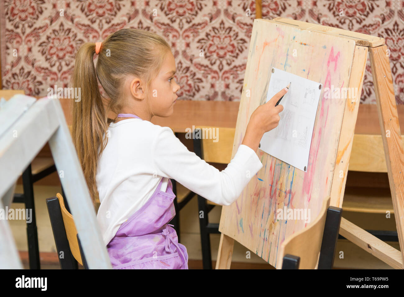 Mädchen-Farben auf einer Staffelei in der Zeichnung Lektion Stockfoto