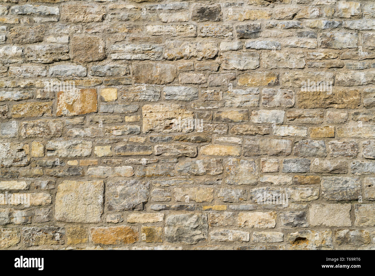 Alte und verwitterte Wand aus verschiedenen Steinen Stockfoto