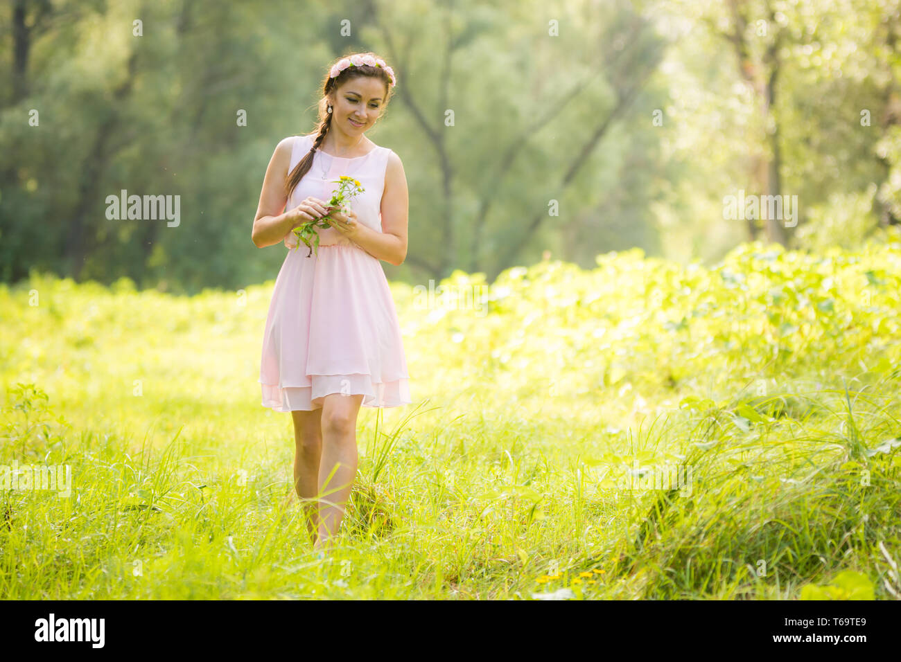 Junges Mädchen im leichten Sommerkleid, sammeln von wilden Blumen Stockfoto