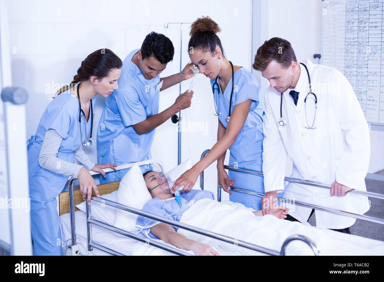 Ärzte Patienten eine Sauerstoffmaske aufsetzen und Anpassung der Tropf Stockfoto