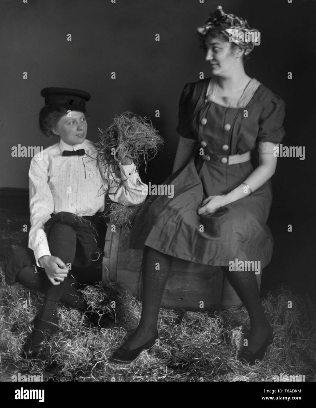 Zwei Frauen sitzen mit einem Faß und Spielen im Heu, Ca. 1910. Stockfoto