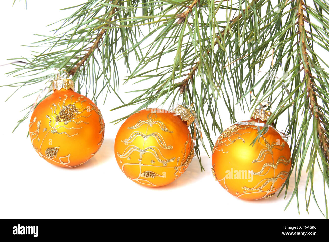 Weihnachtsbaum und Drei goldene Weihnachtskugeln. Auf weiß Isoliert Stockfoto