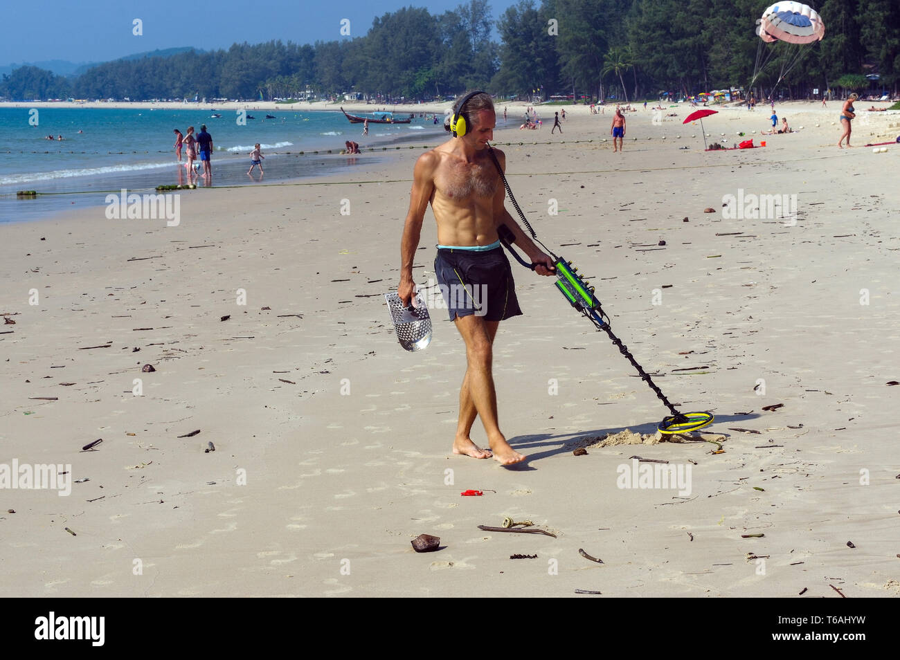 Treasure Hunter mit Metalldetektor am Strand Stockfoto