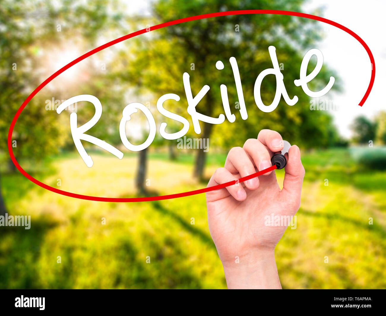 Mann Hand schreiben Roskilde mit schwarzem Marker auf visuelle Bildschirm Stockfoto