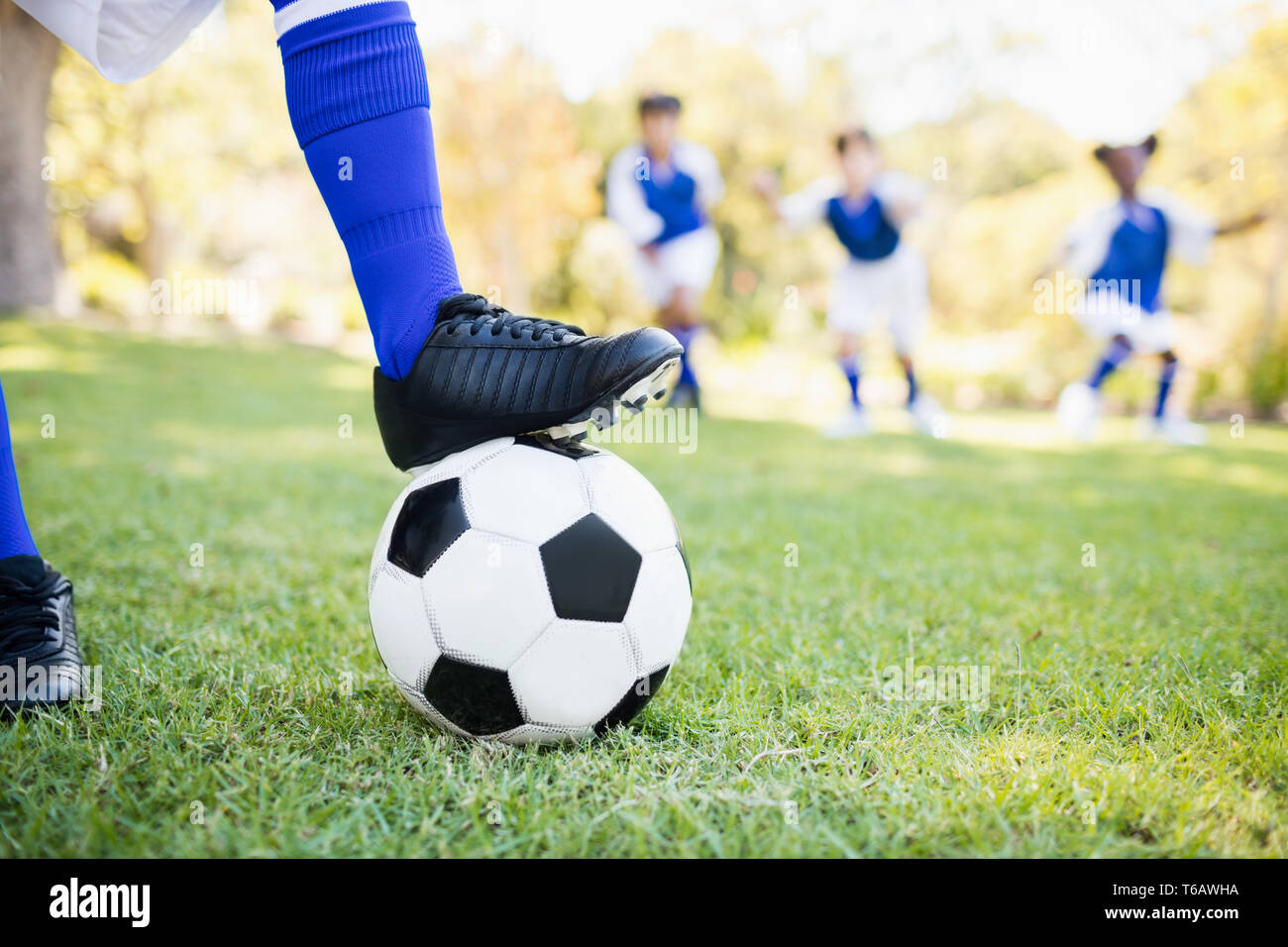 Nahaufnahme der Ballon unter Fußballschuhe gegen Hintergrund spielende Kinder Stockfoto