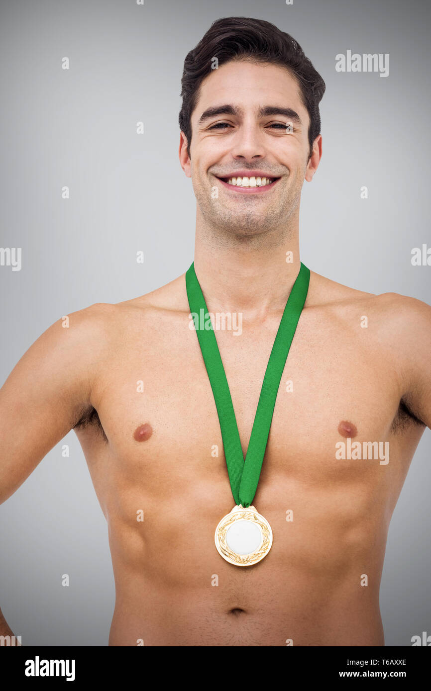 Zusammengesetztes Bild des Athleten posiert mit Goldmedaille auf weißem Hintergrund Stockfoto