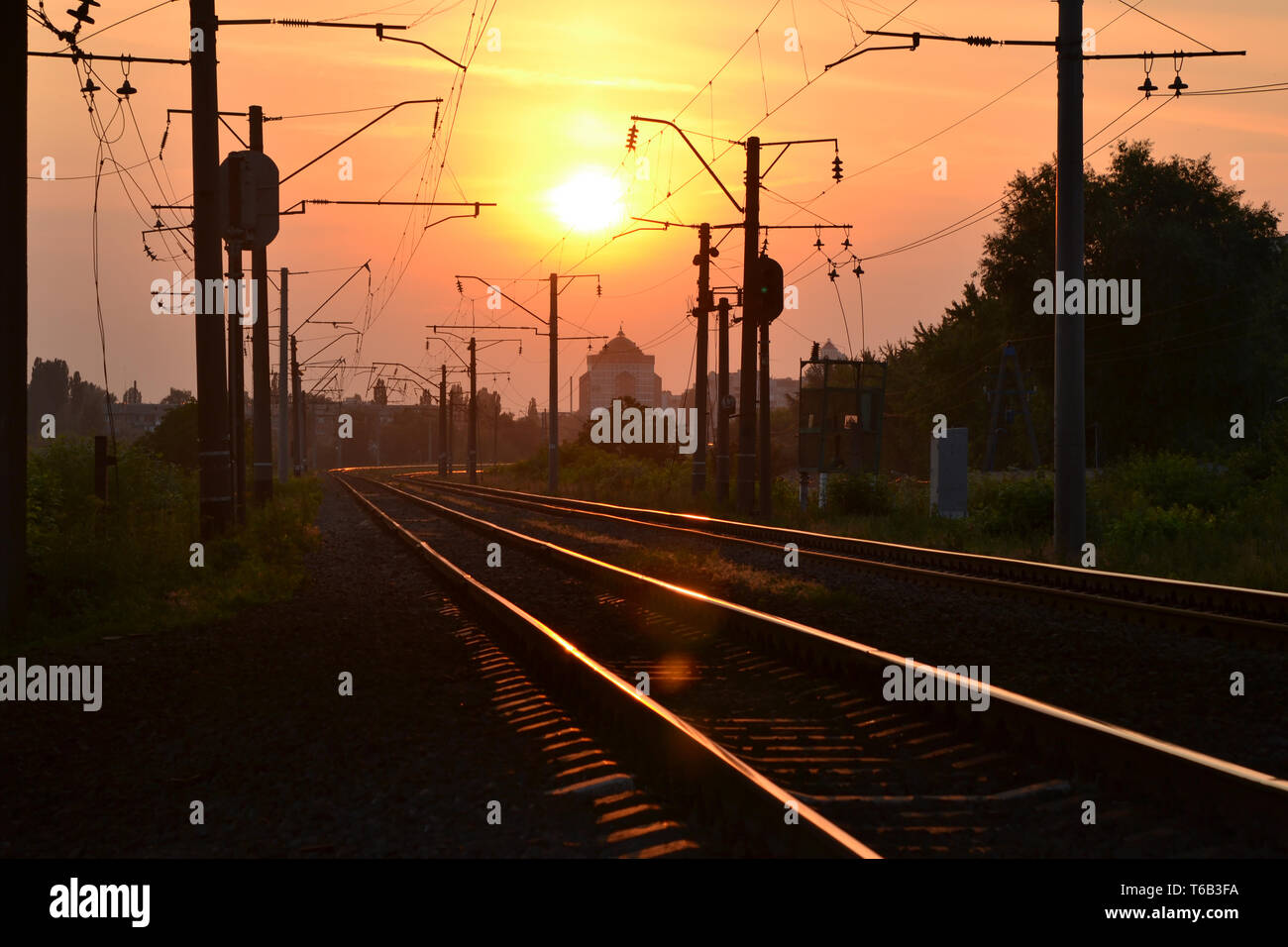 Auf schienen bei Sonnenaufgang Sonnenuntergang wider, Eisenbahnschienen bei Sonnenuntergang Dämmerung Stockfoto