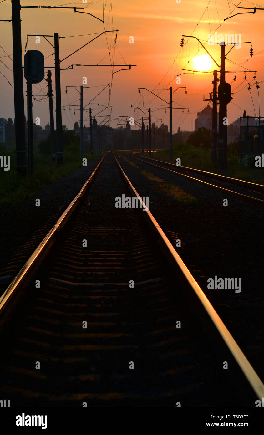 Auf schienen bei Sonnenaufgang Sonnenuntergang wider, Eisenbahnschienen bei Sonnenuntergang Dämmerung Stockfoto