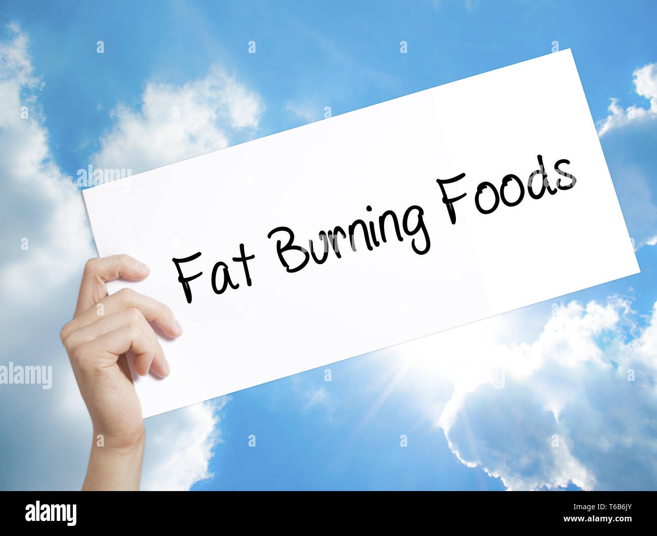 Fat Burning Foods Zeichen auf weißem Papier. Mann Hand, Papier mit Text. Auf Himmel Hintergrund isoliert Stockfoto