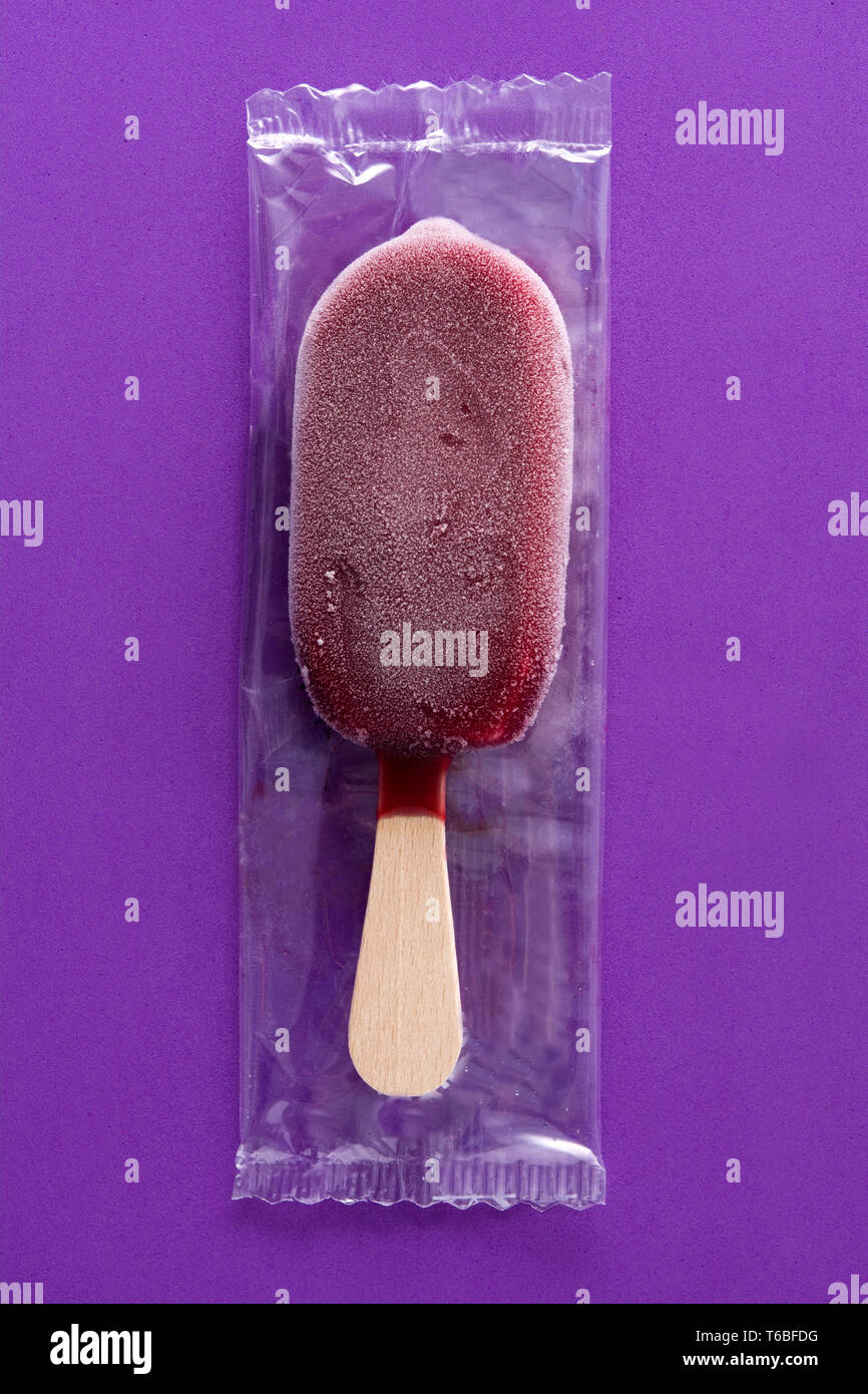 Verpackt Erdbeere popsicle auf Violett Hintergrund. Stockfoto