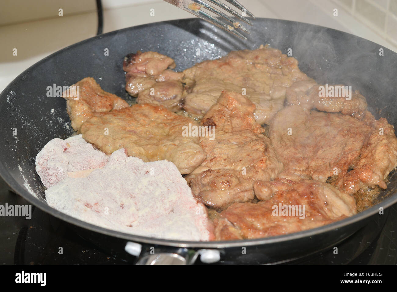 Kochen Fleisch in einem Topf auf einer induktionsplatte Stockfoto