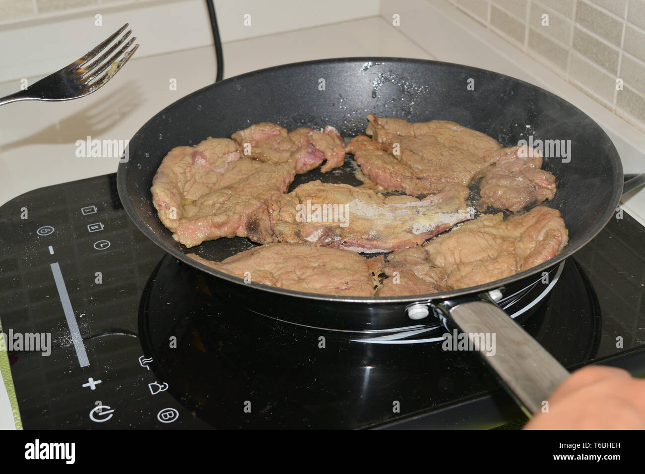 Kochen Fleisch in einem Topf auf einer induktionsplatte Stockfoto