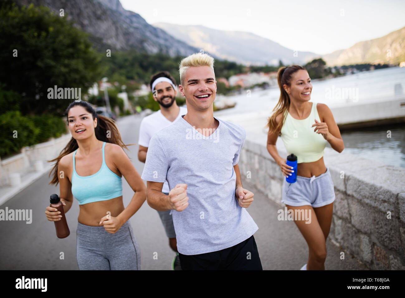 Glückliche Menschen Joggen im Freien. Laufen, Sport, Bewegung und gesunde Lebensweise Konzept Stockfoto