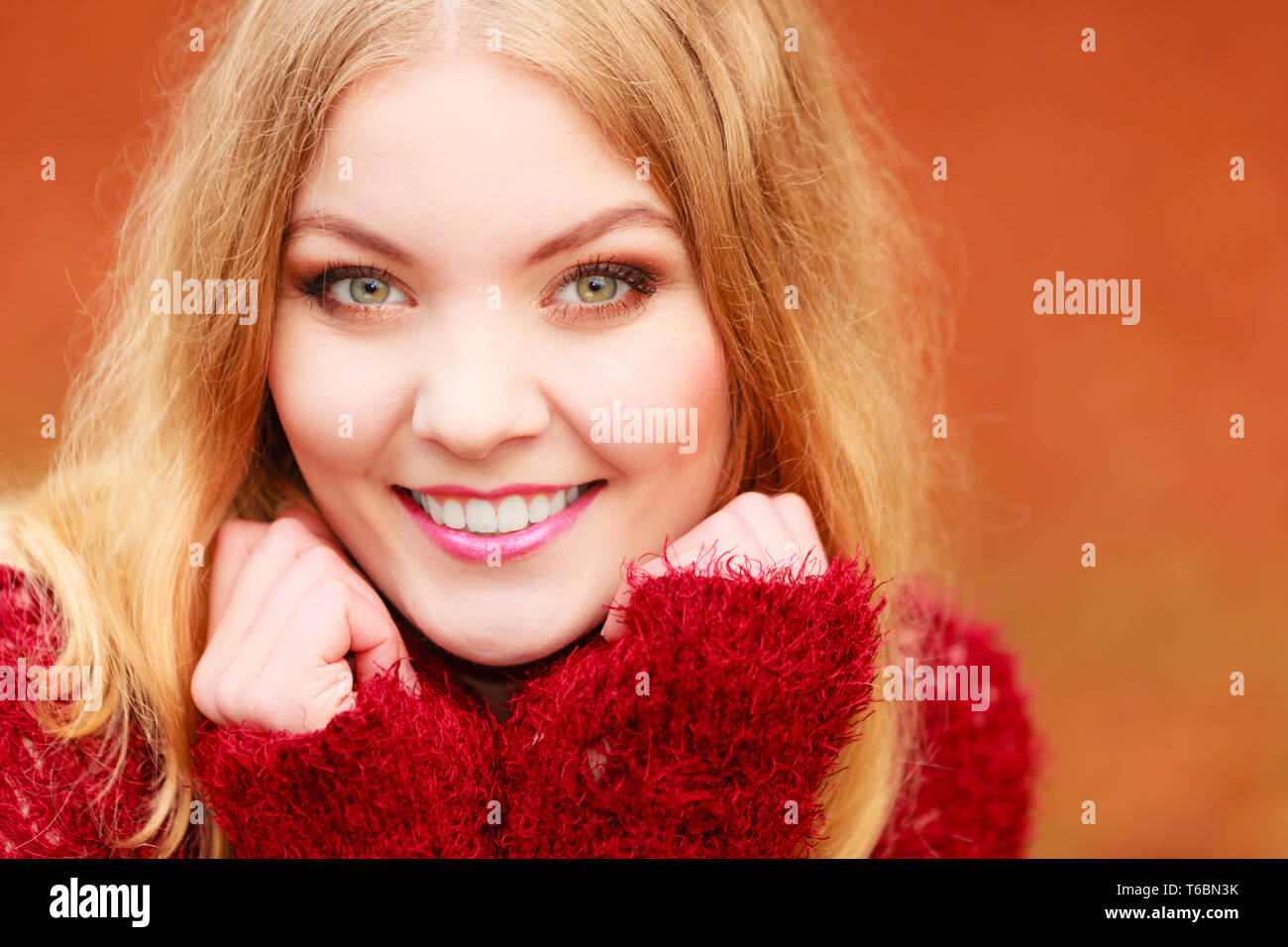 Portrait von atemberaubend schönen Lächeln modische Frau im Herbst Forest Park. Gerne wunderschöne junge Mädchen in dunkelbraunen Pullover Pullover. Herbst Winter Mode Stockfoto