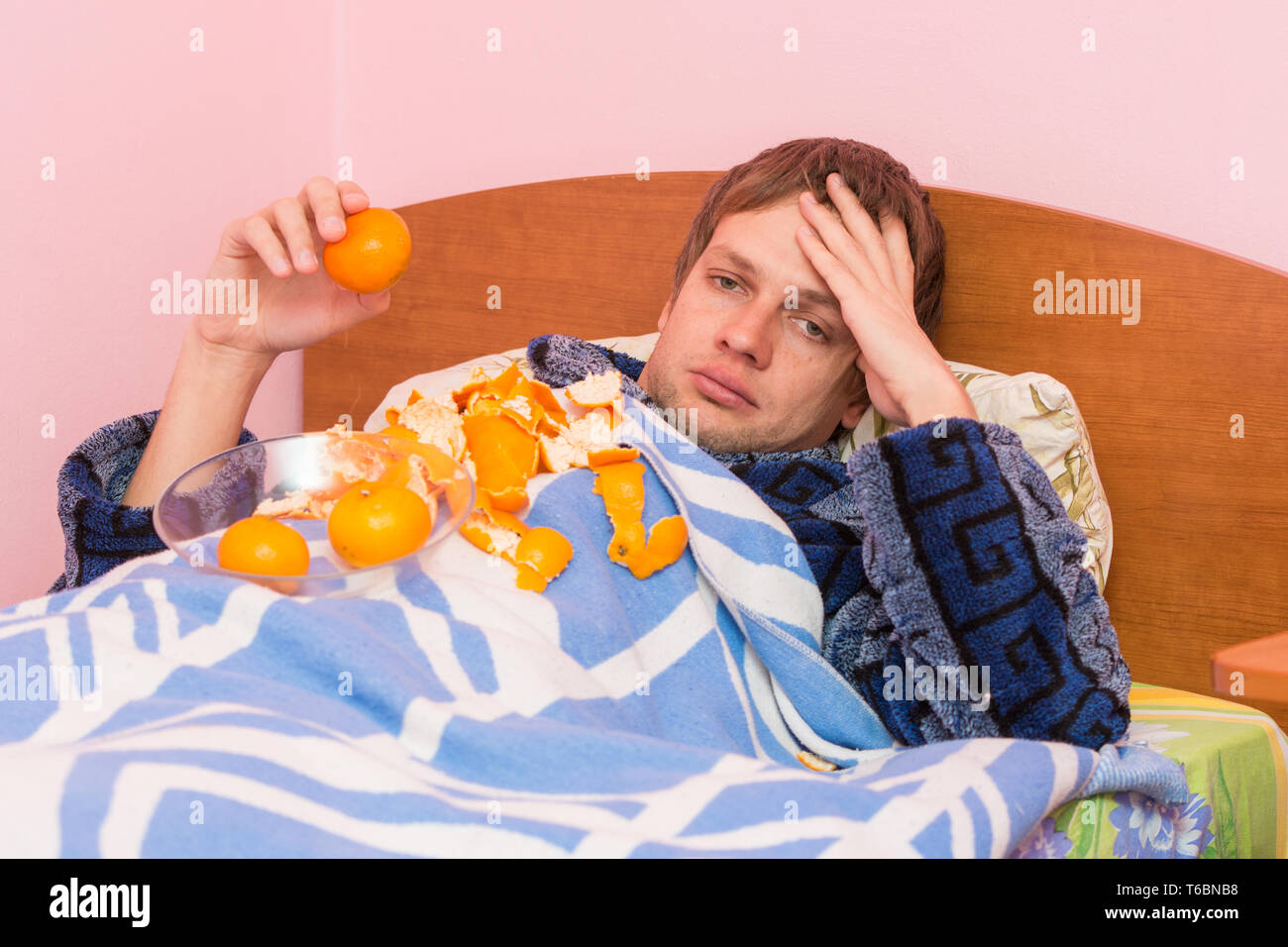 Trauriger Mann Mandarinen vollgefressen selbst sieht im Rahmen Stockfoto