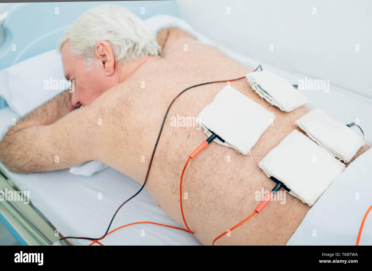 Die physiotherapeutische Behandlung. Ältere Patienten mit Ultraschall und Elektrotherapie Behandlung auf seinem Rücken Stockfoto
