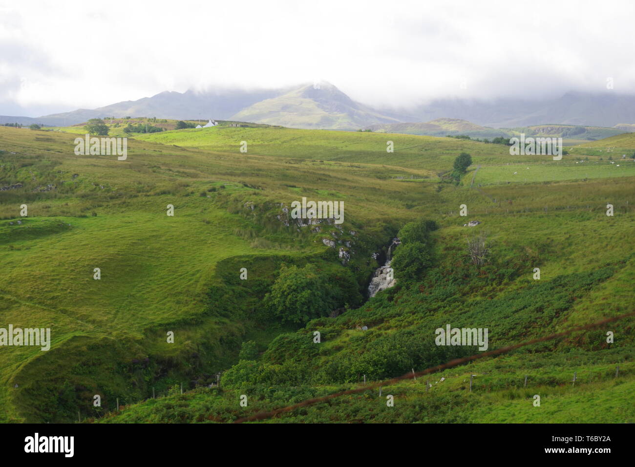 Lonfearn Brennen durch pulsierende grüne Landschaft unter niedrigen Cloud mit Berge bei Brüder Point (Rubha nam Brathairean) Isle of Skye, Schottland, Großbritannien. Stockfoto