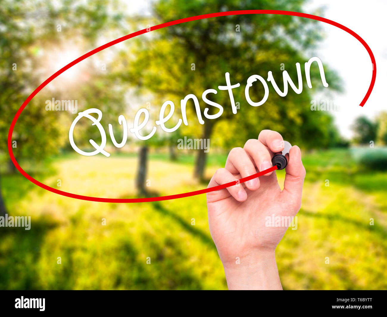Mann Hand schreiben Queenstown mit schwarzem Marker auf visuelle Bildschirm Stockfoto
