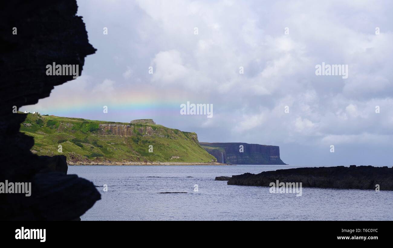 Kilt Rock und Mealt fällt unter einem Regenbogen aus Rubha nam Brathairean (Brüder) North East Skye, inneren Hebridies, Schottland, Großbritannien. Stockfoto