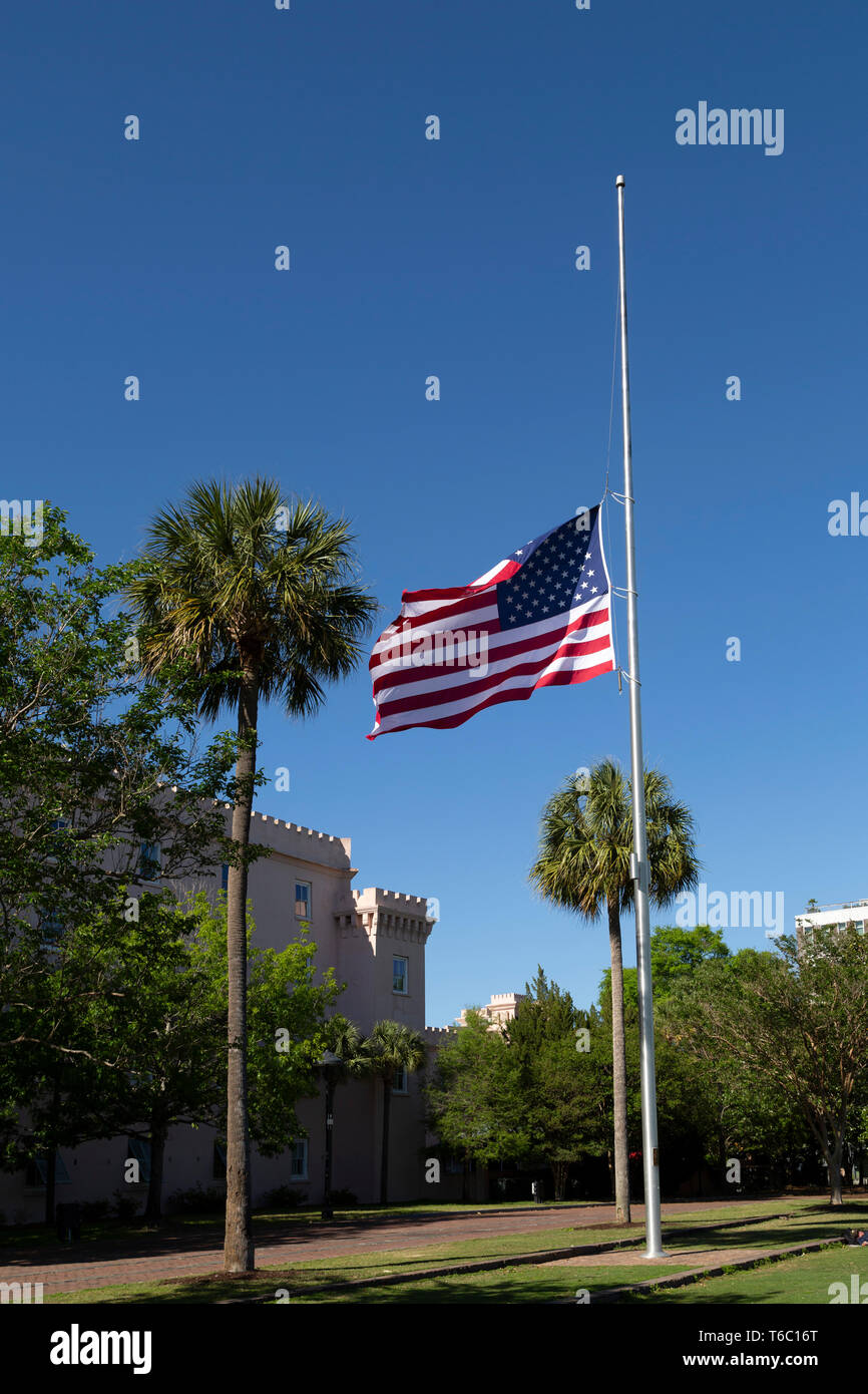 Das Sternenbanner fliegt auf die Hälfte - Personal in Charleston, South Carolina, USA. Das Flag Pole ist außerhalb der alten Zitadelle bei Marion Square. Stockfoto